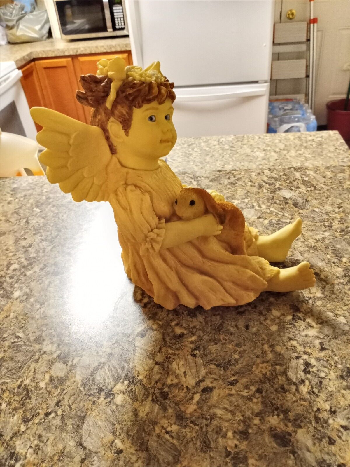 Christmas Guardian Angel holding bunny while sitting down