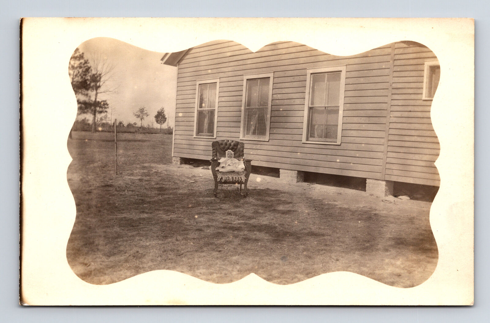 RPPC Baby Seated in Rocking Chair in Yard Odd Postcard