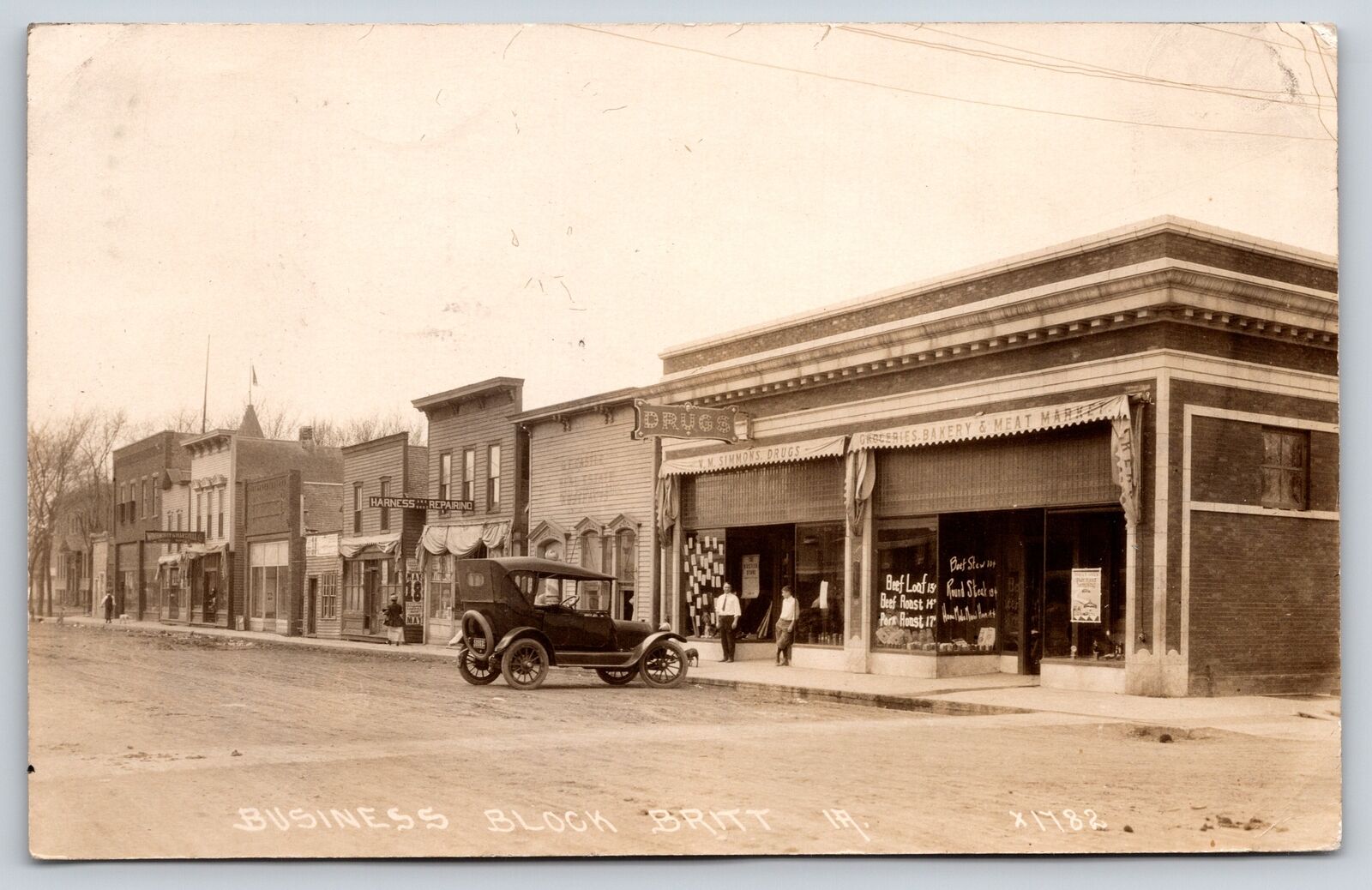 Britt Iowa~Business Block~Drug Store~Meat Market 14c lb~Harness Shop~1920 RPPC