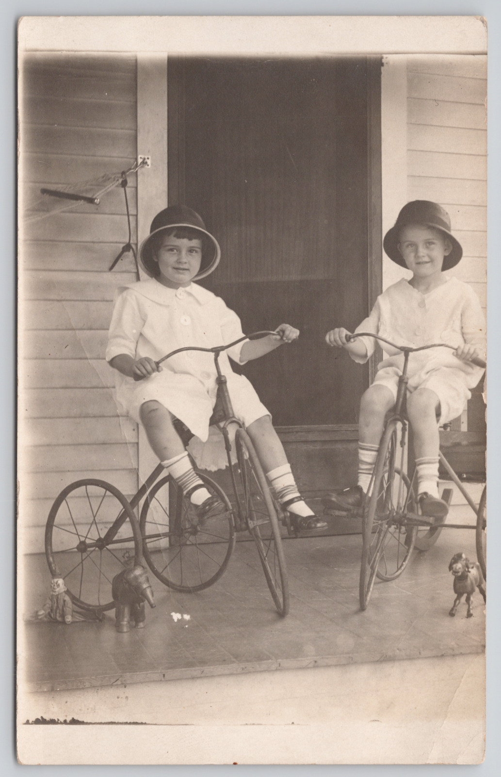 Real Photo Postcard Two Children on Porch with Tricycles and Toys c1920 RPPC