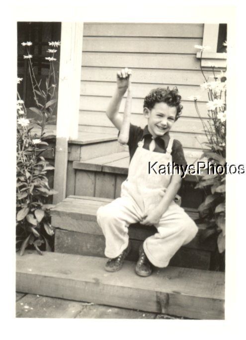 FOUND B&W PHOTO H_9702 LITTLE BOY SITTING ON STEP HOLDING A CARROT