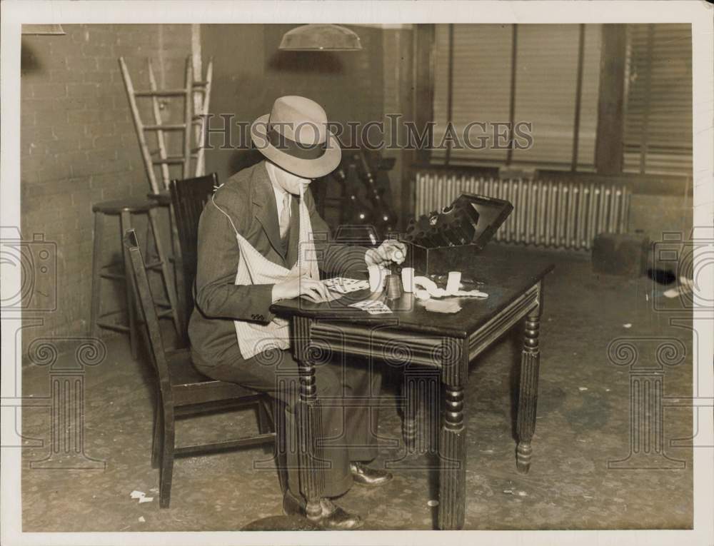 1935 Press Photo Detective examines gambling equipment found in Cosmos Club