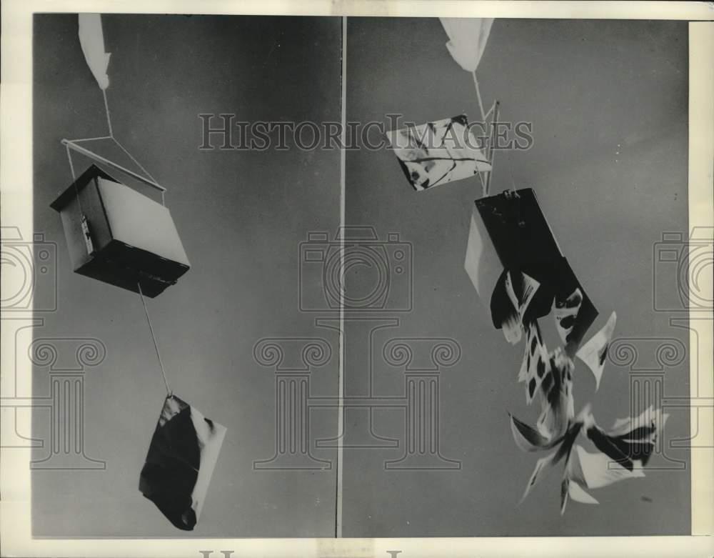 1956 Press Photo Balloon carries package; paper drops out of box on balloon
