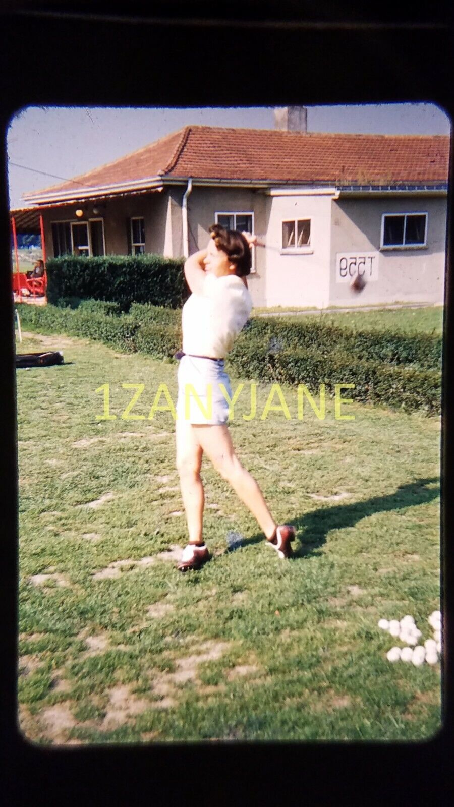 AO09 VINTAGE 35mm SLIDE TRANSPARENCY Photo WOMAN TEEING OFF CLUBHOUSE BACKGROUND