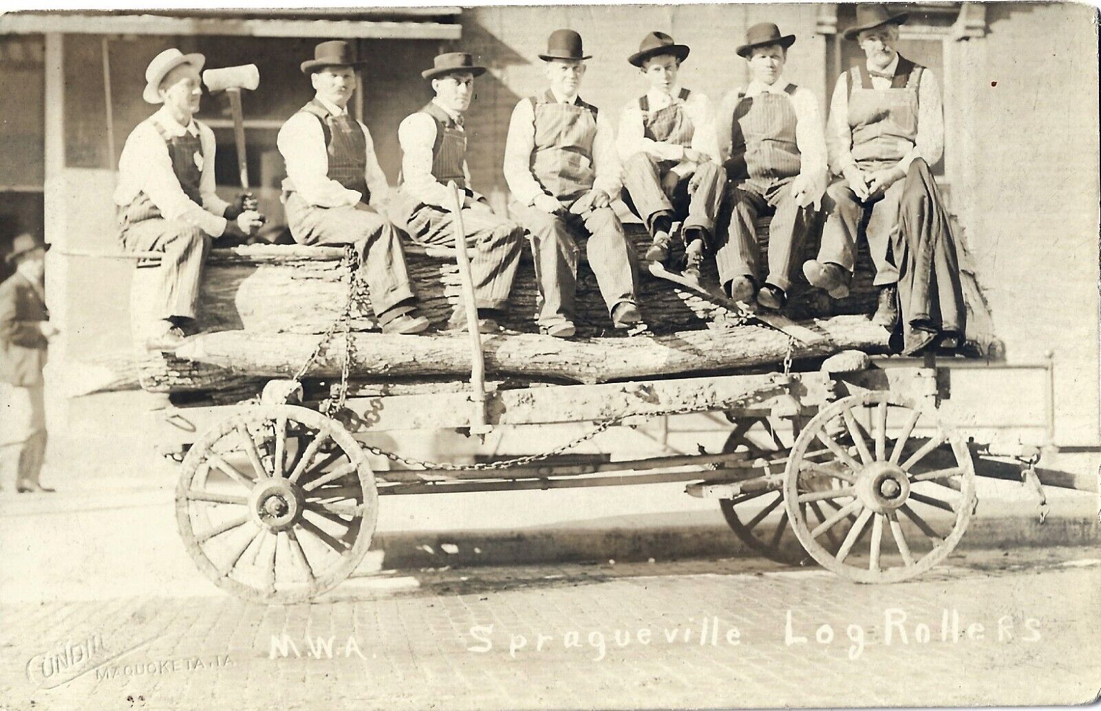 Spragueville IA -- Log Rollers w/axes on wagon; IDs on back; nice 1910s RPPC