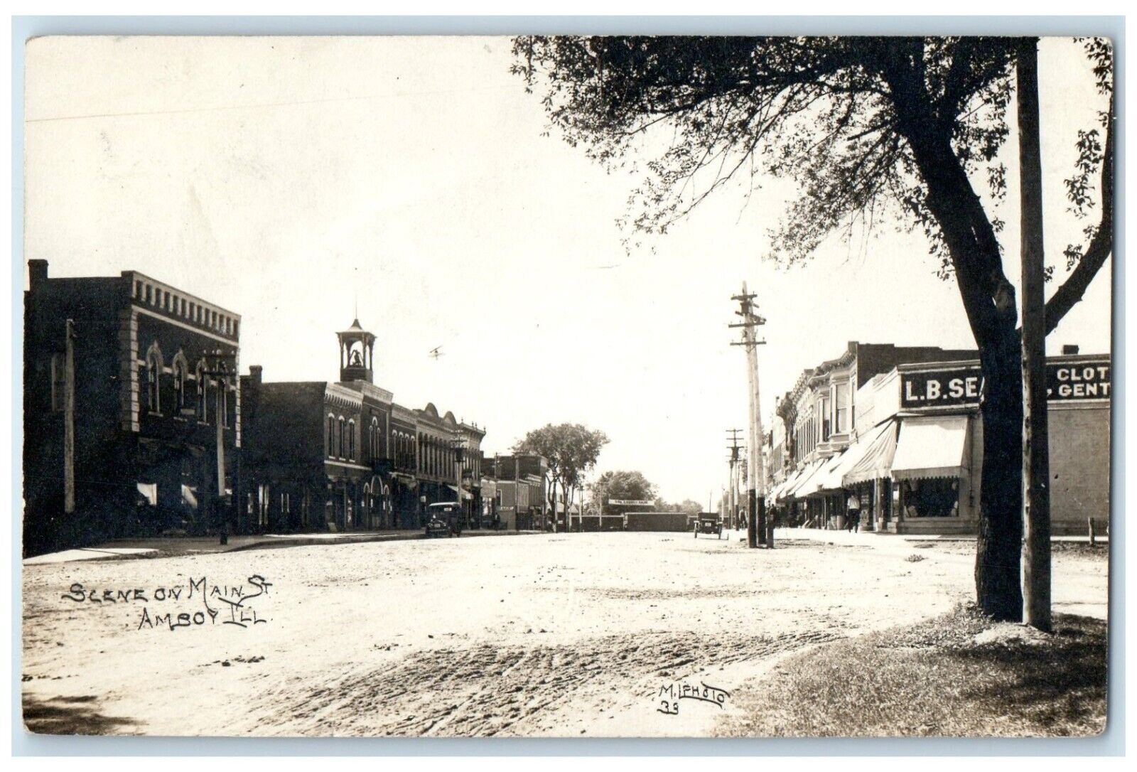 1912 Scene On Main Street Dirt Road Building Cars Amboy IL RPPC Photo Postcard