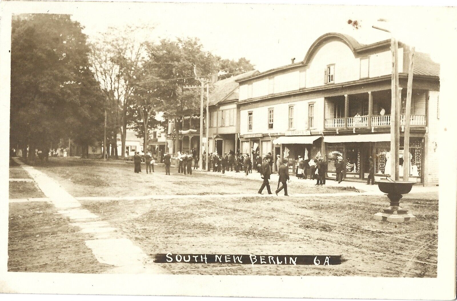 South New Berlin NY -- stores, street band, residents; nice 1913 RPPC