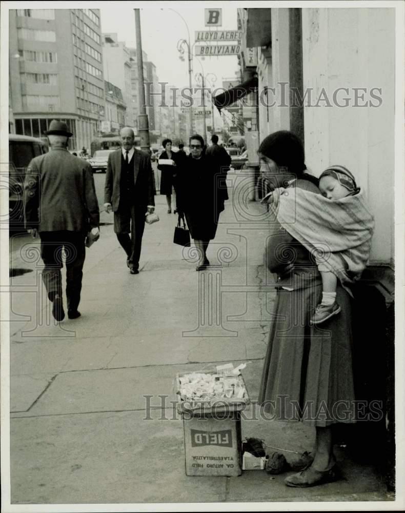 1971 Press Photo Mom Sells Wares on Street While Child Sleeps on Her Back, Peru