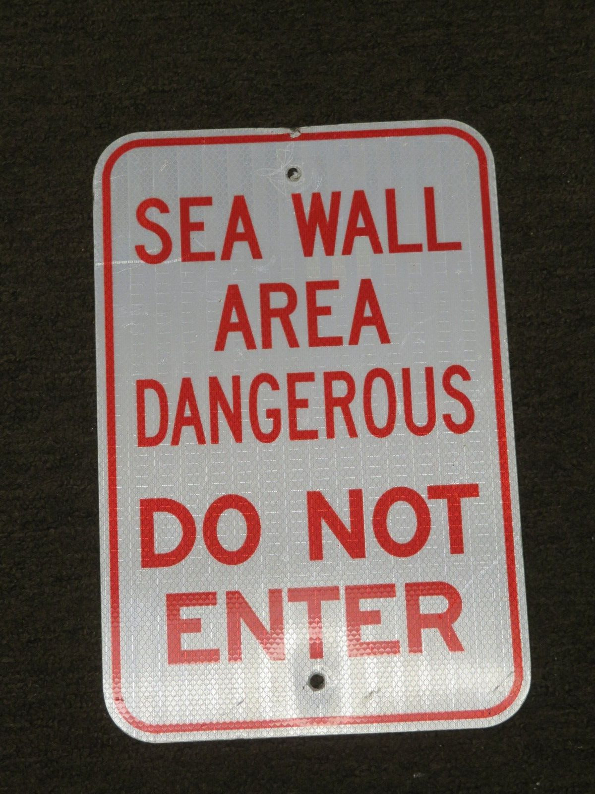 SEAWALL AREA DANGEROUS DO NOT ENTER RETIRED SIGN
