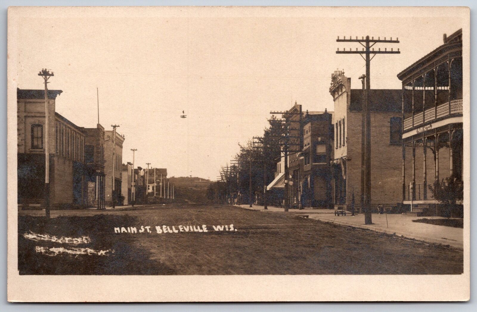 Belleville WI~Dirt Main Street~Hotel~Various Sized Utility Poles~c1907-15~RPPC