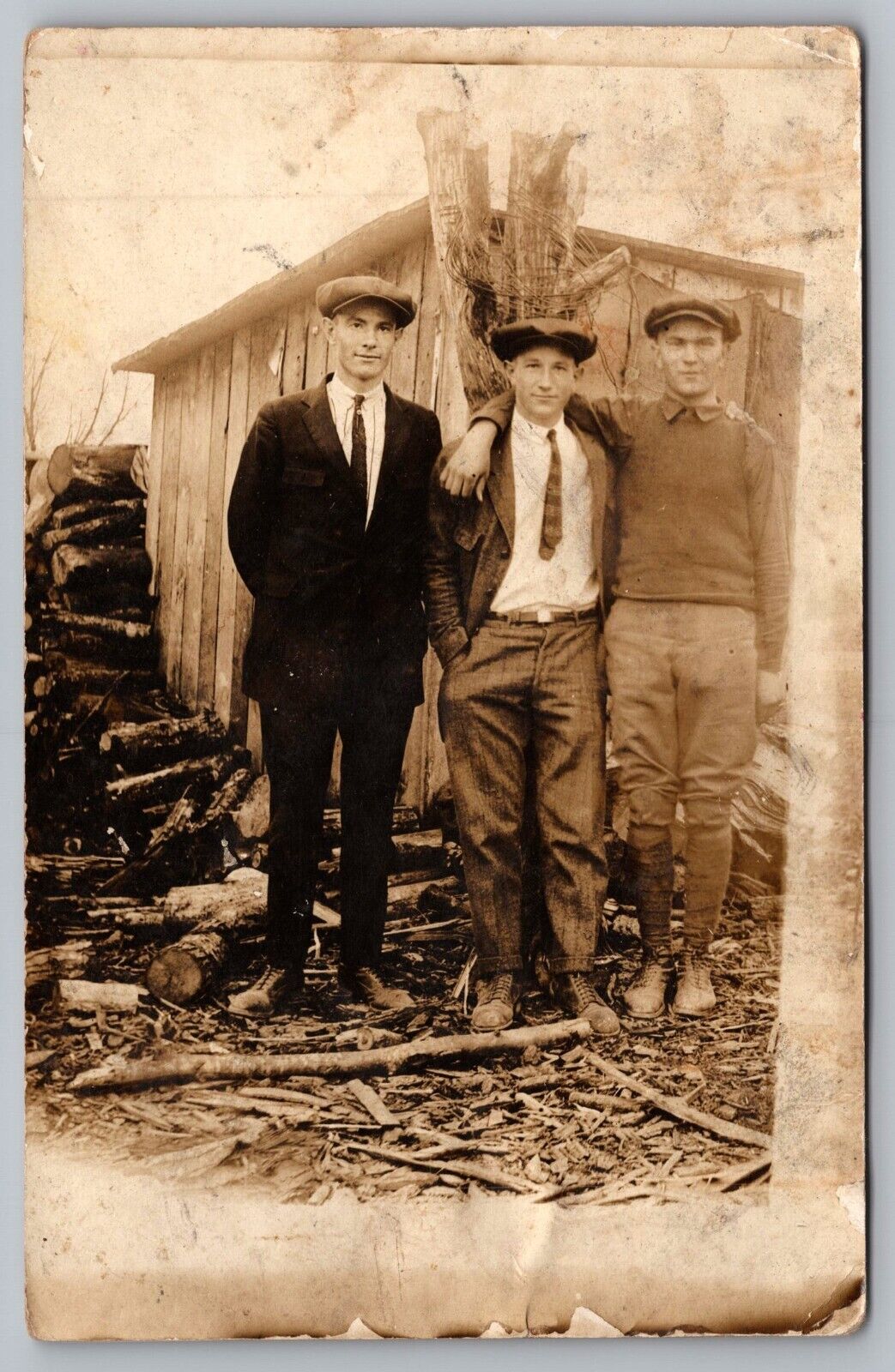 RPPC Three Handsome Men Standing by Wood Shed Postcard