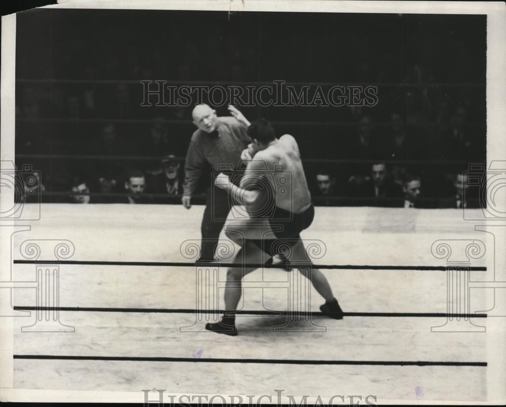 1932 Press Photo Two men face off in a wrestling ring as refereee stand by