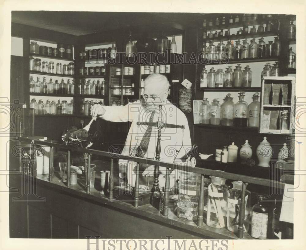 1973 Press Photo An elderly man cleans the counter of the drug store - lra58845
