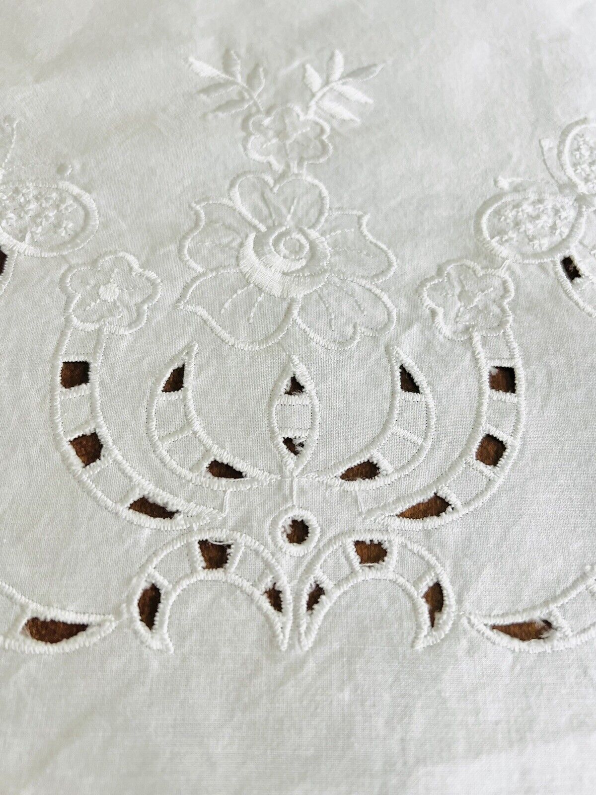 White round tablecloth with white embroidered flowers butterflies and cut outs