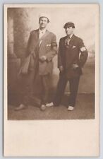 RPPC Men Standing In Studio Messenger Bag Arms On Hip c1910 Real Photo Postcard picture