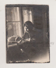 Mother Holding Her Baby Tenderly by the Window Silhouetted Against the Light picture
