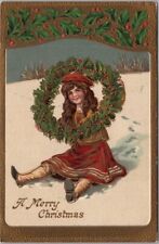 Vintage 1912 MERRY CHRISTMAS Embossed Postcard Girl on Snow Hill / Holly Wreath picture