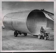 1963 Press Photo Tiny Tractor Pulling Giant cylinder at K-P construction Co. picture