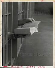 1970 Press Photo Two inmates share Bible through cells. - hpa12308 picture