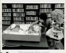 1989 Press Photo Winston Lynk & Jenna Falcone admire dolls, Coral Gables Library picture