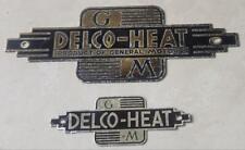 2 VINTAGE DELCO HEAT PRODUCT OF GM GENERAL MOTORS METAL ADVERTISING TAG EMBLEM picture