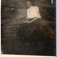 c1910s Weird Edwardian Woman Sits in Wood Pile RPPC Creepy Smile Real Photo A140 picture