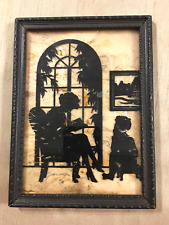 vintage silhouette reverse painting of mom reading story to son