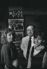 1989 Press Photo Three River Lane Team Members in Front of Old Team Photographs picture