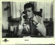 1986 Press Photo James Gardner shown talking on two telephones in 