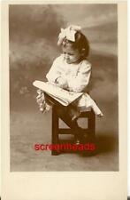 C1910 STUDIO RPPC PHOTO YOUNG SPECTACLED GIRL CHILD READING MAGAZINE OR PAPER VG picture