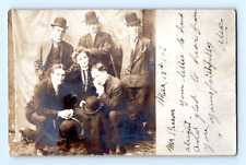 RPPC 1906. MEN SURROUNDING ELDERLY WOMAN. POSTCARD. DD17 picture