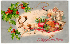 Postcard 1907 Embossed Santa in White Robe Getting a Reindeer to Pull the Sleigh picture
