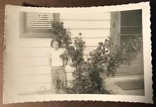 Photo young little girl posing next to Roses by house Cute kid picture