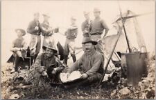 c1910s WWI Military RPPC Photo Postcard Soldiers / Cooking Pots Tents Newspaper picture