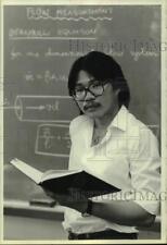1981 Press Photo Scientist Benny Dang in front of chalk board holding book picture