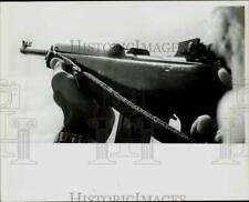 1977 Press Photo Sporting Goods salesman holding an MI carbine gun in Charlotte picture