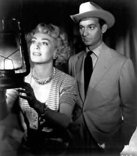 Barbara Stanwyck stares into lamp with unidentified actor or movie picture