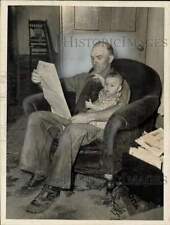 1941 Press Photo Nelson Chester reading newspaper while holding a baby, Ohio picture