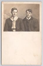 RPPC Two Young Men In Studio In Overcoats c1910 Real Photo Postcard picture