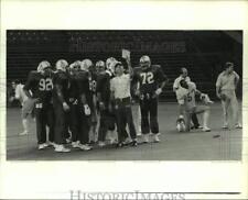 1982 Press Photo Houston Oilers football players gather to look at play card picture