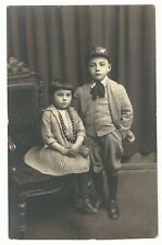 TWO WELL DRESSED SIBLINGS AND A MESSAGE IN A LANGUAGE I CAN NOT IDENTIFY picture