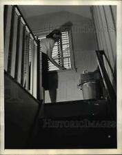 1945 Press Photo Woman Opening Attic Windows for Ventilation picture