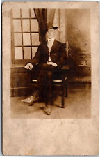 RPPC Confident Whipersnapper in suit and hat sitting next to window picture