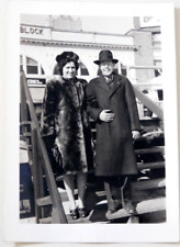 VINTAGE PICTURE OF A WELL DRESSED MAN & WOMAN-LOOKS LIKE A BOARDWALK BEHIND THEM picture
