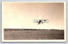 Postcard RPPC Aviator Jimmie Ward Over Field Train Consist in Background picture
