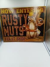 A Tin Sign That Says Now Entering Rusty Nuts Fix-it Shop Pre-owned picture