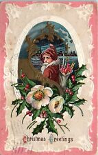 1912 Christmas Greetings Santa Pink Coat Toy Sack and Holly Embossed Postcard picture