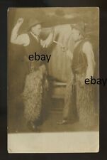 Cowboys in furry leggings. One holds a gun on other. This is a holdup # 5 RPPC picture