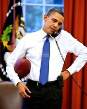 BARACK OBAMA ON THE PHONE WHILE HOLDING A FOOTBALL - 8X10 PHOTO (ZZ-622) picture
