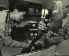 1986 Press Photo Elizabeth Herrera demonstrates gas mask, St. Luke's Hospital picture
